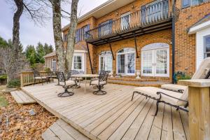 a wooden deck with chairs and a table at Immaculate Boone Villa with Entertainment Lounge! in Boone
