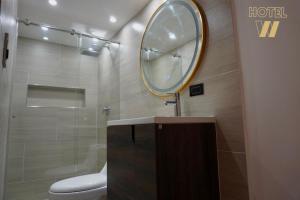 a bathroom with a toilet and a mirror on the wall at HOTEL W Santa Marta in Gaira