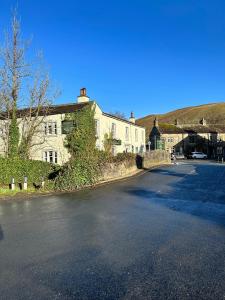 una calle vacía frente a un edificio blanco en The Racehorses Hotel en Kettlewell