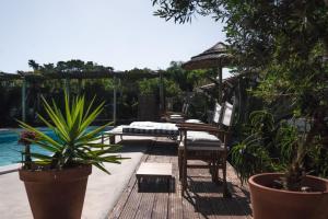 a patio with chairs and an umbrella and a pool at João Jungle in Açafora