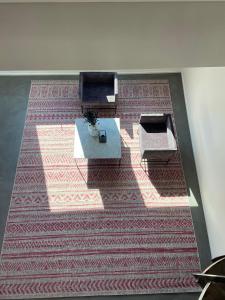 a room with a rug with a table and chairs on it at Suite One Löwengrube in Munich