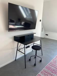 a black desk with a television on a wall at Suite One Löwengrube in Munich
