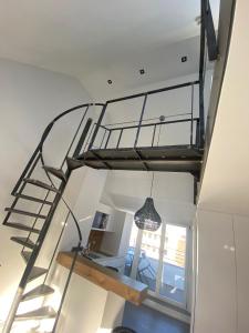 a spiral staircase in a house with a light fixture at Suite One Löwengrube in Munich