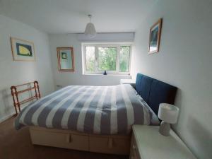 a bedroom with a striped bed and a window at Spacious 3 bedroom house in lovely location in Birmingham