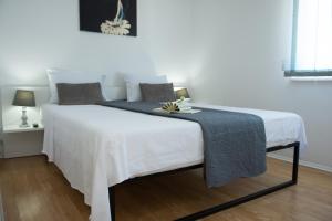 a white bed with a blue blanket on it at Villa Blue Oasis in Kaštela