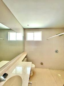 baño con lavabo y aseo y 2 ventanas en Casa De Lujo Frente Al Mar 1, en Cartagena de Indias