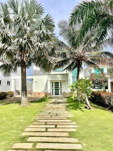 un camino de piedra frente a una casa con palmeras en Casa De Lujo Frente Al Mar 1, en Cartagena de Indias