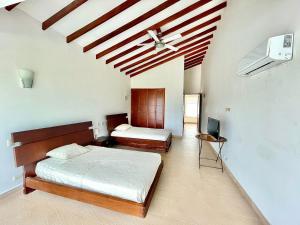 1 dormitorio con 2 camas y techo en Casa De Lujo Frente Al Mar 1, en Cartagena de Indias