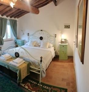 a bedroom with a white bed and a green cabinet at B&B La Rosa Nel Verde in Lucca