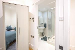 Schlafzimmer mit einem Bett, einem Waschbecken und einem Spiegel in der Unterkunft City Centre, Spacious, Ensuite, Smart TV, Sofa Bed in Bristol