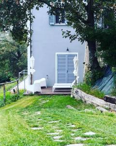una casa blanca con un banco y un árbol en Cascina GianTino G A Y - ONLY suite Cantina, en Montegrosso dʼAsti