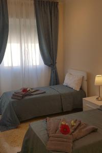 a bedroom with two beds with towels and a window at Residenze Benedetto Croce in Bari