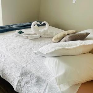 two swans made out of towels sitting on a bed at Hotel Chão Mineiro in São Thomé das Letras