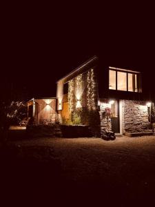 un edificio de noche con luces encendidas en La Petite Grange - Spa Balnéo, en Vigneux-de-Bretagne