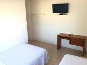 a bedroom with a bed and a desk and a tv at Liza, habitación privada de Flor de Lis Beach House in Playas