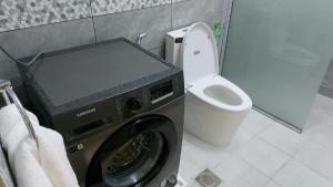 a bathroom with a washing machine and a toilet at شقة مفروشة ليالي العروبة متميزة مؤثثة بأثاث أنيق ومريح in Riyadh