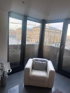 a white couch in a room with large windows at LUXURY Apartment Belfast City Centre overlooking Custom House Sqaure in Belfast