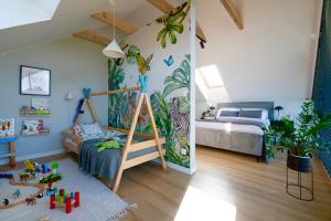 a childrens room with a bed and a bedroom with plants at Kalwa Lake House - dom nad jeziorem z prywatnym pomostem i jacuzzi oraz sprzętem wodnym in Pasym