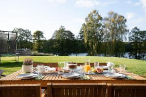 a wooden table with food on top of it at Kalwa Lake House - dom nad jeziorem z prywatnym pomostem i jacuzzi oraz sprzętem wodnym in Pasym