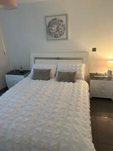 a bedroom with a white bed with two pillows at LUXURY Apartment Belfast City Centre overlooking Custom House Sqaure in Belfast