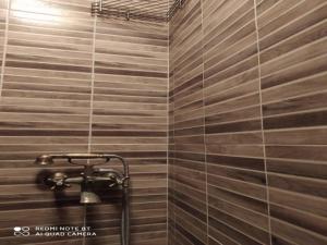 a shower in a bathroom with wooden tiles at NAOUSA 1 in Naousa Imathias