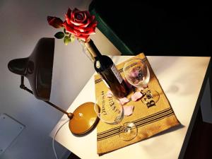 una mesa con una botella de vino y un jarrón con una rosa en DIMORA PIETRAMORE, en Brindisi