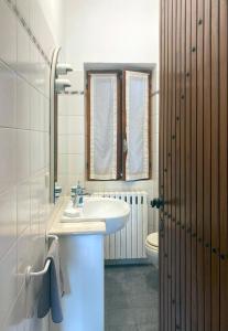uma casa de banho com um lavatório e um WC em IRIS - Relaxing Alpine Getaway at Ballabio em Ballabio
