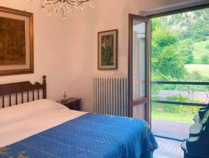 um quarto com uma cama e uma grande janela em IRIS - Relaxing Alpine Getaway at Ballabio em Ballabio