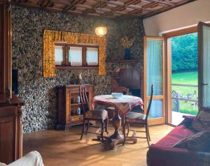 um quarto com uma mesa e cadeiras e uma janela em IRIS - Relaxing Alpine Getaway at Ballabio em Ballabio