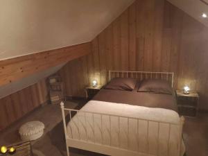 une chambre avec un lit dans une pièce aux murs en bois dans l'établissement Appartement à la montagne, à Villar-dʼArêne