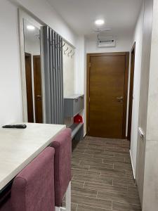 um quarto com uma cozinha com um balcão e uma porta em President Kopaonik Apartman l/ll 