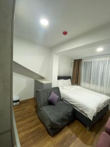 1 dormitorio pequeño con 1 cama y 1 sofá en President Kopaonik Apartman l/ll 