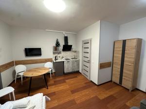 a living room with a table and a kitchen at Modern Apartments Uzhgorod in Uzhhorod
