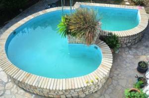 an overhead view of a large blue swimming pool with plants at Apartment Margerita in Asgourou