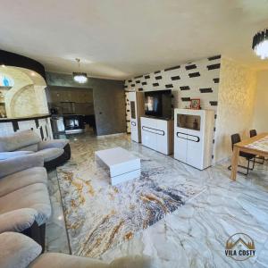 un soggiorno con pavimento in marmo e una cucina di Vila Costi a Campina