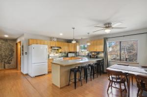 eine Küche mit weißem Kühlschrank und Holzschränken in der Unterkunft Single Tree Cottage - Walk to Downtown Chama! in Chama