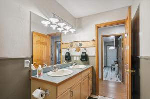 ein Badezimmer mit zwei Waschbecken und einem großen Spiegel in der Unterkunft Single Tree Cottage - Walk to Downtown Chama! in Chama