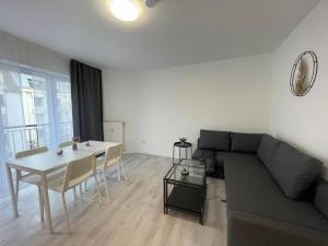 City Apartment am Rhein Bonn في بون: غرفة معيشة مع أريكة وطاولة