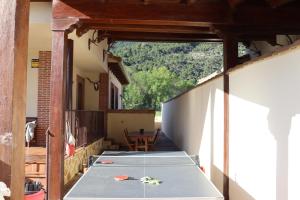 una casa en construcción con una mesa en el balcón en Casa en sierra de gredos piscina privada, en La Adrada