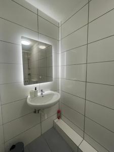 City Apartment am Rhein Bonn في بون: حمام أبيض مع حوض ومرآة