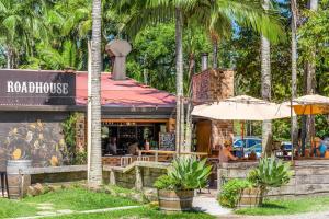 a restaurant with an umbrella and palm trees at Light Filled Modern Specious Home, Pet friendly in a beautiful area of Byron Bay, short stroll to town in Byron Bay