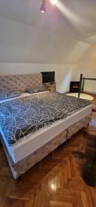 a large bed in a room with a cat on the floor at Holiday Home Oaza Mira in Visoko