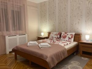ein Schlafzimmer mit einem Bett mit zwei Handtüchern darauf in der Unterkunft Fürdő Apartman in Makó