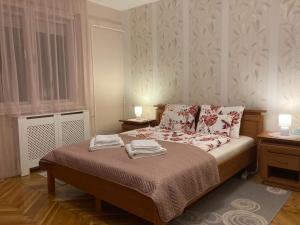 sypialnia z łóżkiem i dwoma ręcznikami na nim w obiekcie Fürdő Apartman w mieście Makó
