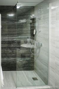 La salle de bains est pourvue d'une douche en verre et d'un lavabo. dans l'établissement La Codrii Cajvanei, 