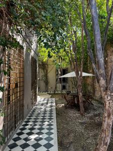 a courtyard with a checkered floor and a picnic table at Casa Charlotte - Alma Hotels in Santa Marta