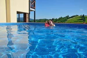 a woman and a child in a swimming pool at Penzion Na Vršku in Branná