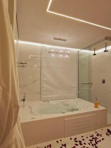 a bathroom with a tub with a glass shower at Pousada Pinhão e Poesia in Canela
