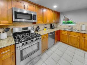 a kitchen with a stove and a microwave at Oceanfront Condo with Front Patio, Gas Grill, Fire Pit - Prime Location!! in San Diego