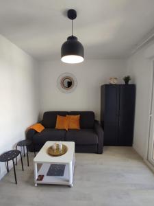 ein Wohnzimmer mit einem Sofa und einem Tisch in der Unterkunft Studio proche gare in Reims